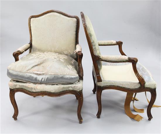 A pair of Louis XV provincial French beech framed fauteuils,